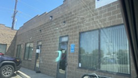 Exterior view of Clinical Consultants facility showing brick facade, main entrance with glass doors, signage, and parking area