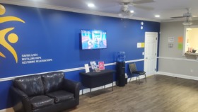 Interior reception lobby with blue accent wall, Spero Health logo, leather seating, and mission statement signage