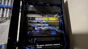 Interior view of network server equipment with blue cable management, switches, and electronic components mounted in black cabinet