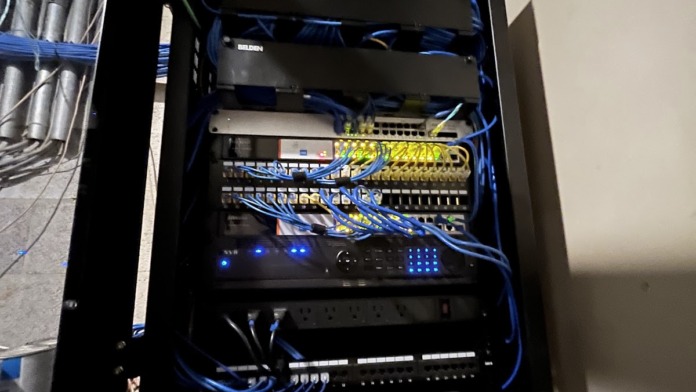 Interior view of network server equipment with blue cable management, switches, and electronic components mounted in black cabinet