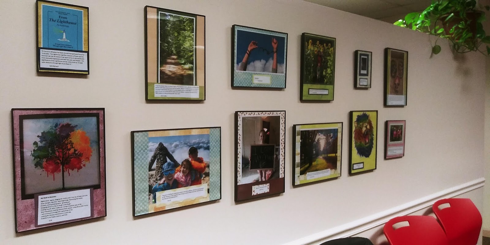 Interior wall displaying framed patient artwork, nature scenes, and inspirational messages with colorful matting and professional framing