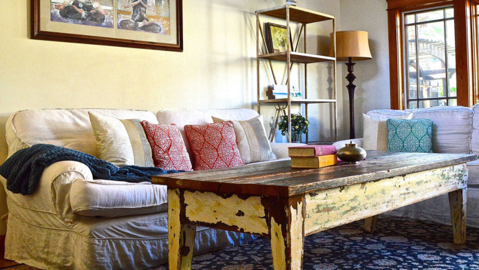 Interior sitting area with upholstered sofa, decorative throw pillows, wooden coffee table, and framed wall art