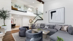 Spacious interior living room area at Calabasas Recovery Center, featuring a large gray sectional sofa and modern decor.