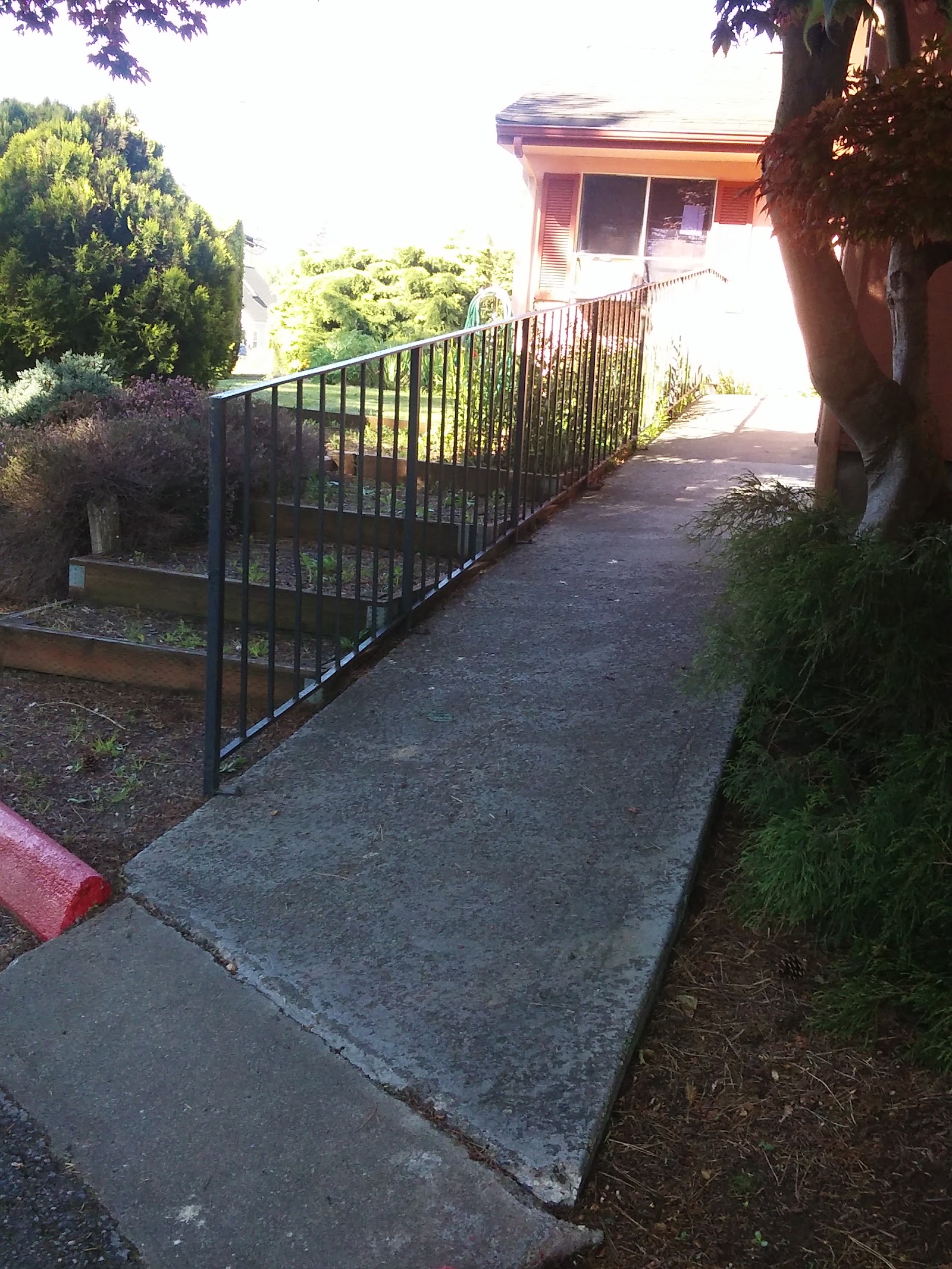 Exterior showing accessible pathway with black metal railing leading to facility entrance with building structure