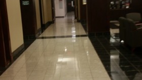 Interior hallway with administration signage, dark wood paneling, tiled flooring, and professional workplace setting