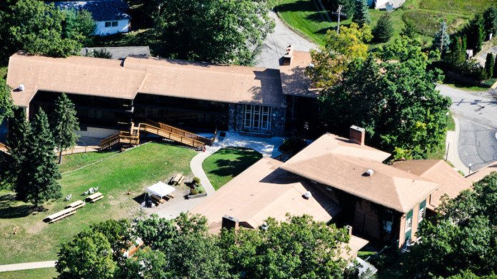 Overhead view of facility campus showing connected buildings, grounds, landscaping, and surrounding vegetation
