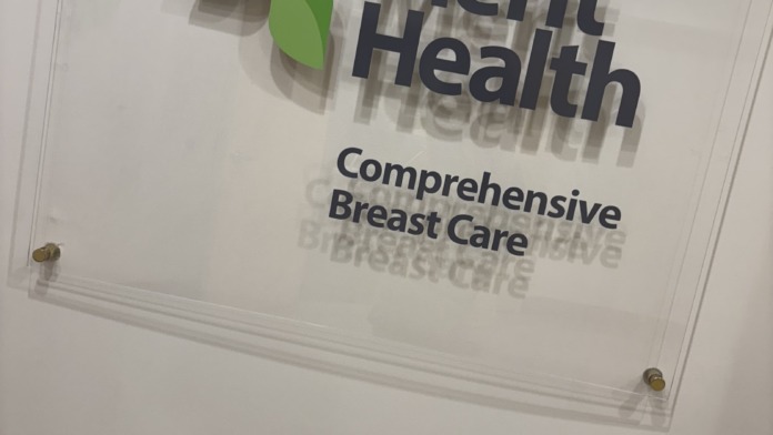 Interior frosted glass panel displaying Merit Health logo and Comprehensive Breast Care signage.