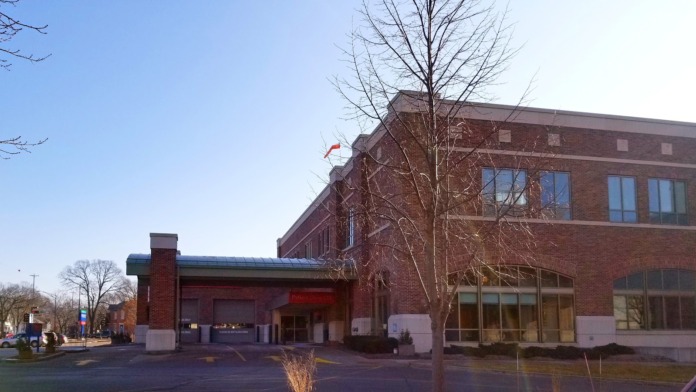 Exterior view of brick medical building with entrance canopy, trees and landscaping