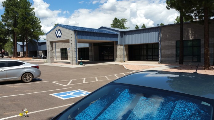 Exterior view of VA facility showing entrance area with covered walkway, parking spaces, and landscaping