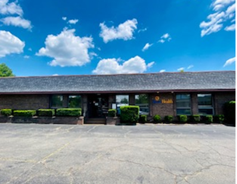 Exterior view of single-story treatment facility with brick facade, landscaping, and parking lot