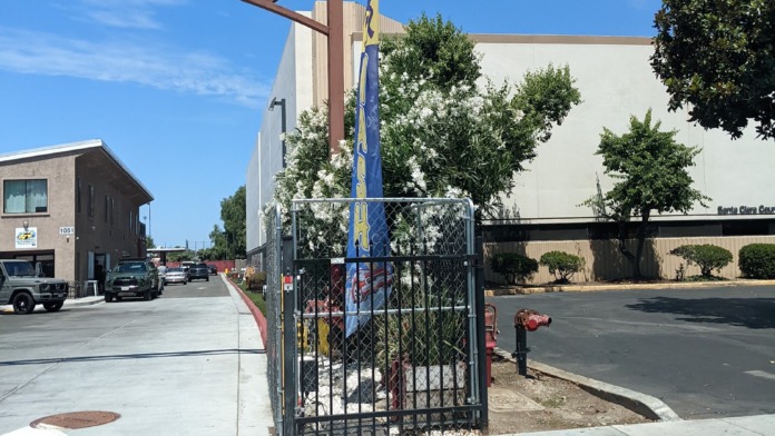 Exterior showing facility building facade with parking area and neighboring structures