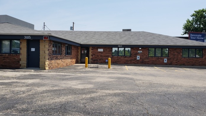 Exterior full-length view of brick treatment facility building with entrance doors, windows, and address numbers displayed
