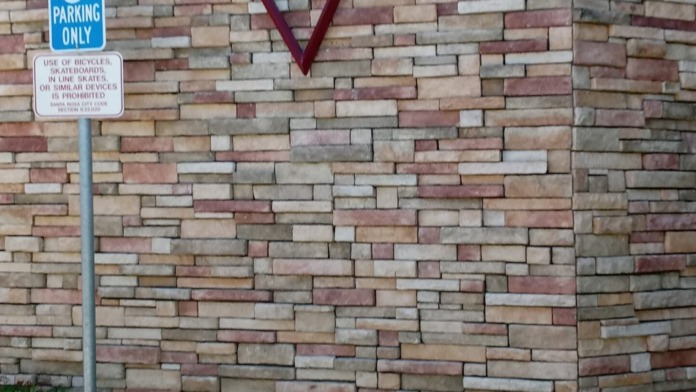 Exterior brick wall with purple Victory logo and handicapped parking sign visible