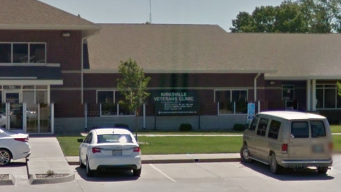 Exterior view of brick medical facility with parked vehicles and landscaped grounds visible from parking lot.