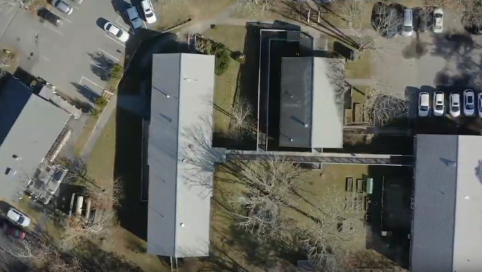 Aerial view of facility campus showing multiple buildings, parking areas, and landscaped grounds layout