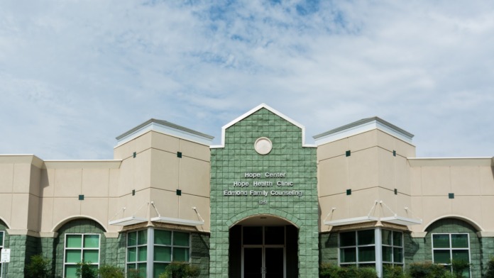 Exterior view of main entrance showing central gabled section with Edmond Family Counseling signage and landscaping