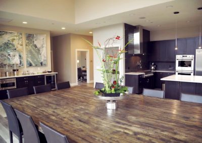 Interior kitchen and dining space with wood island countertop, dark cabinetry, seating area, and open floor plan design
