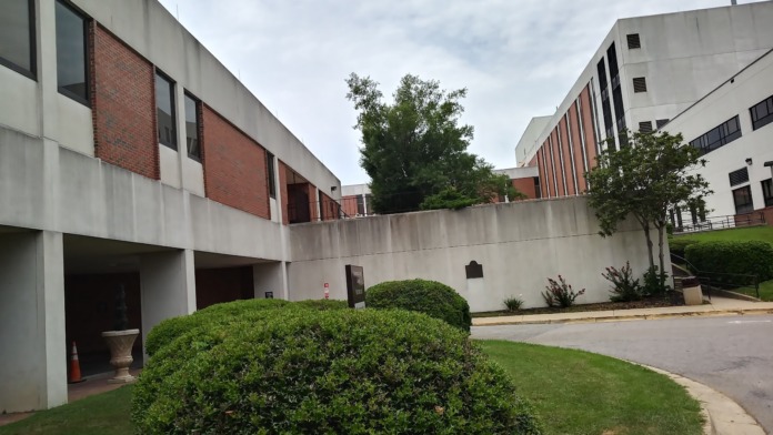 Exterior institutional building with multi-level design, brick facade, and landscaped grounds