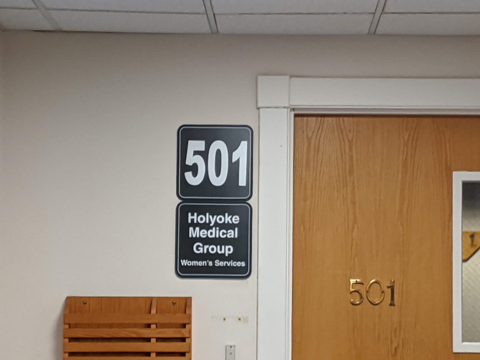 Interior hallway with directional signage, restroom access, and wayfinding for laboratory waiting and medical services