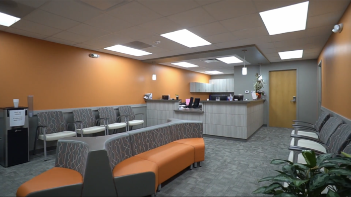 Interior corridor with treatment room entrances, decorative flags and posters, and natural skylight illumination