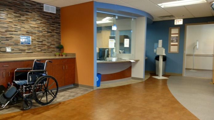 Interior clinical space with reception desk, colorful accent walls in orange and blue, modern flooring and furniture