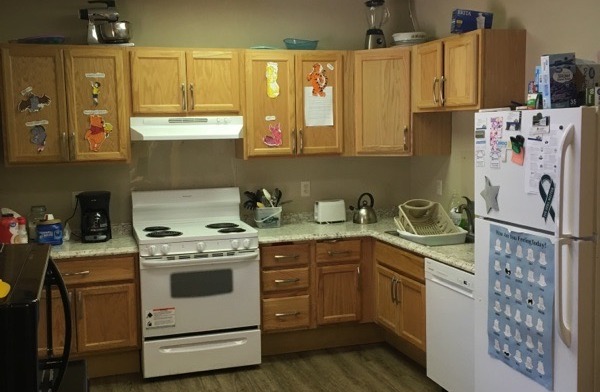 Interior kitchen with wooden cabinetry, white appliances, countertops, and meal preparation area