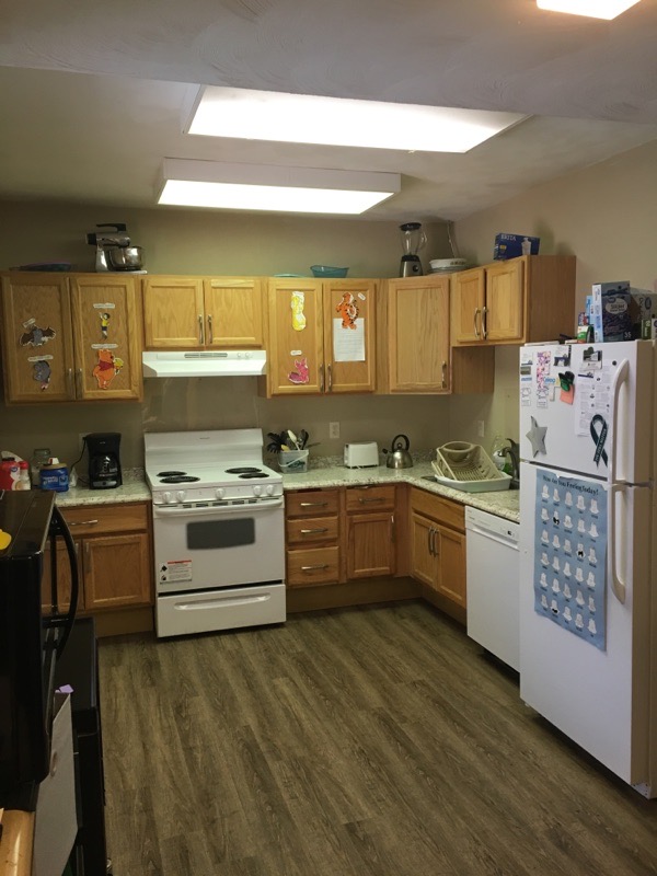 Interior kitchen with wooden cabinetry, white appliances, countertops, and meal preparation area