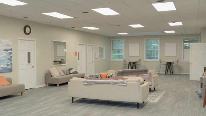 Interior lounge space with comfortable seating, couches, armchairs, and natural lighting from large windows