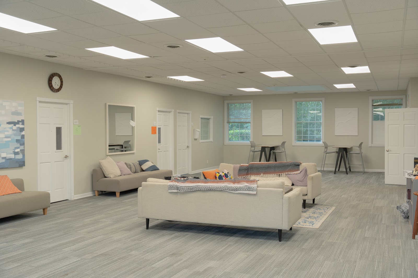 Interior lounge space with comfortable seating, couches, armchairs, and natural lighting from large windows