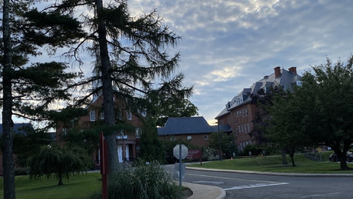 Exterior daytime view of facility entrance with parking, mature trees, and brick buildings