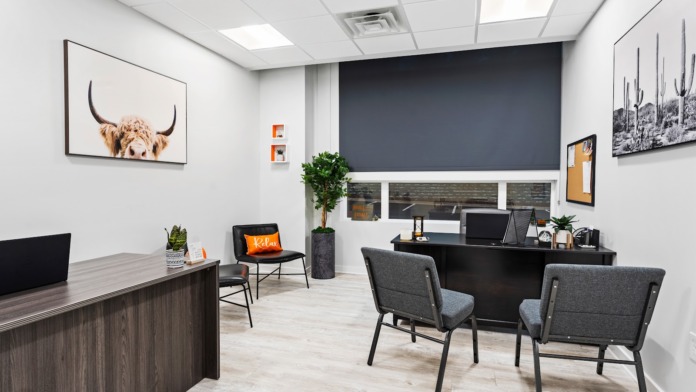Interior counseling office with desk, motivational artwork, plant, office furniture, and professional decor