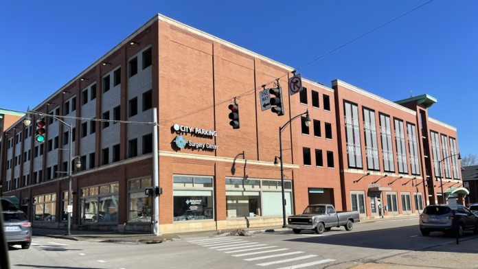 Exterior brick building on downtown corner with storefront windows and street level entrance