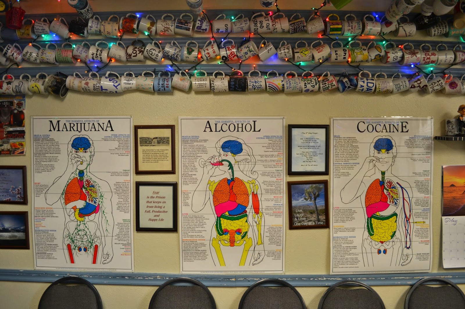 Interior lounge with educational substance abuse charts on walls, decorative mugs, inspirational signage, and comfortable seating