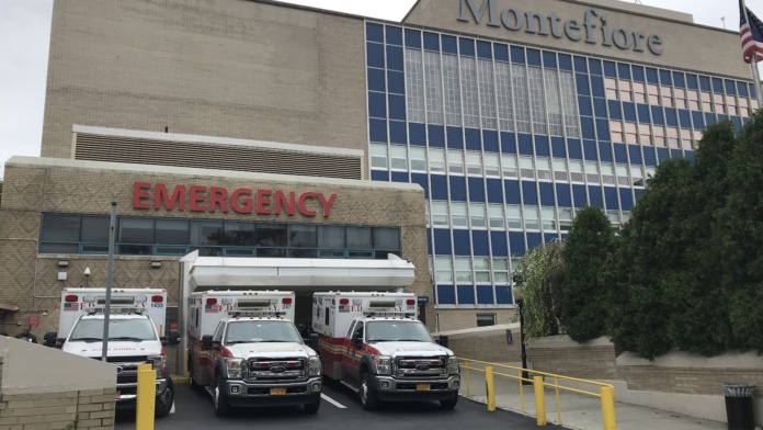 Exterior showing emergency entrance with ambulance bay, Montefiore signage, and multi-story facility building