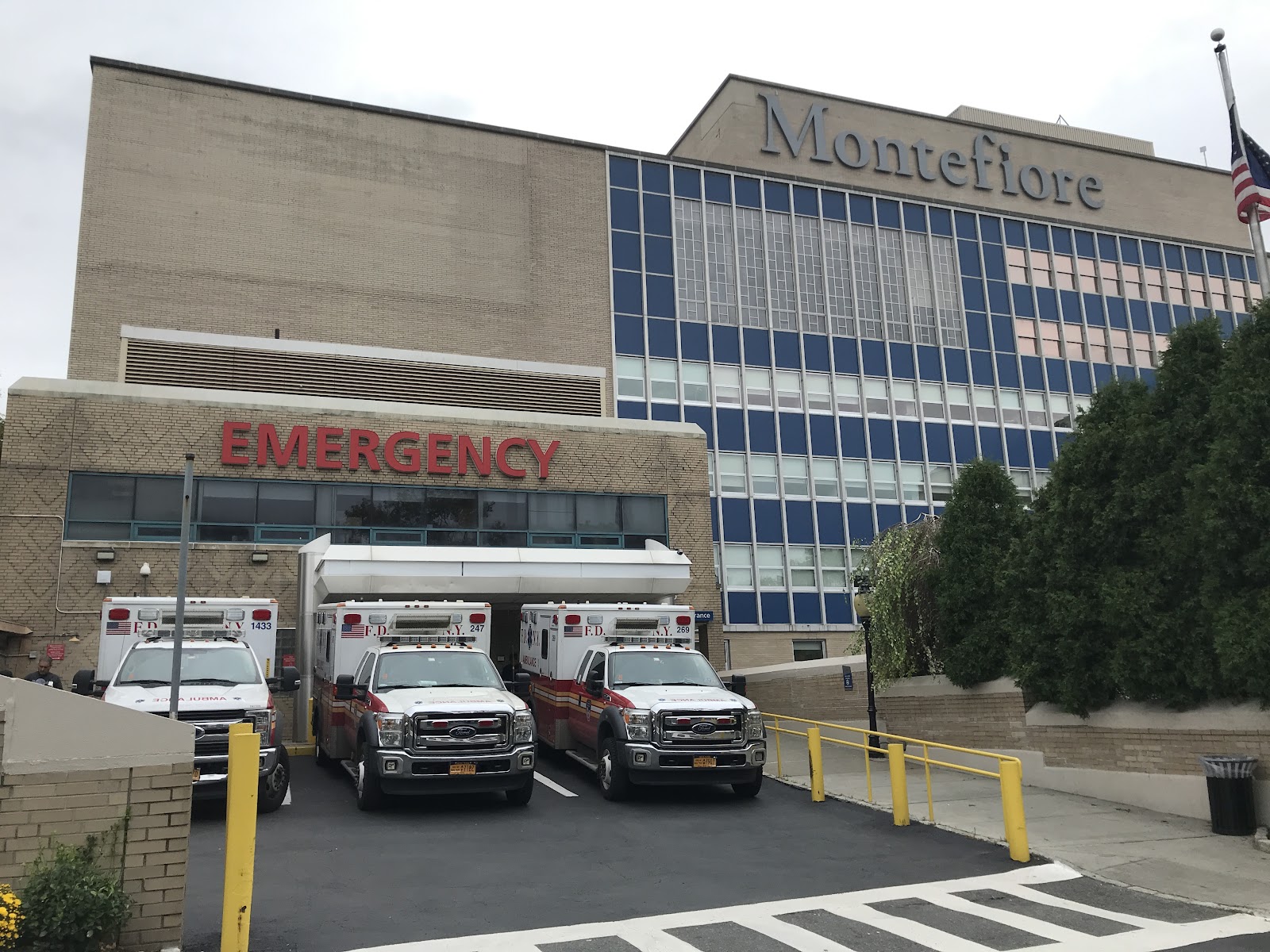 Exterior showing emergency entrance with ambulance bay, Montefiore signage, and multi-story facility building
