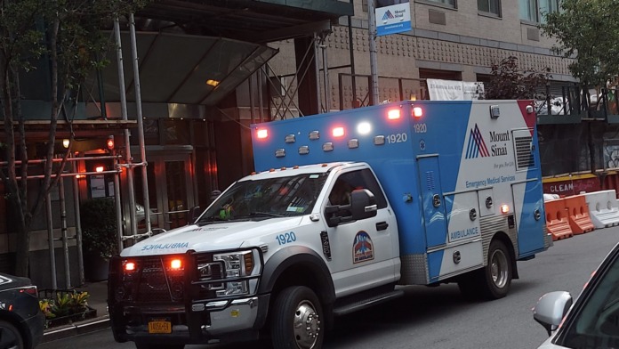 Exterior view of Mount Sinai ambulance stationed outside facility entrance building