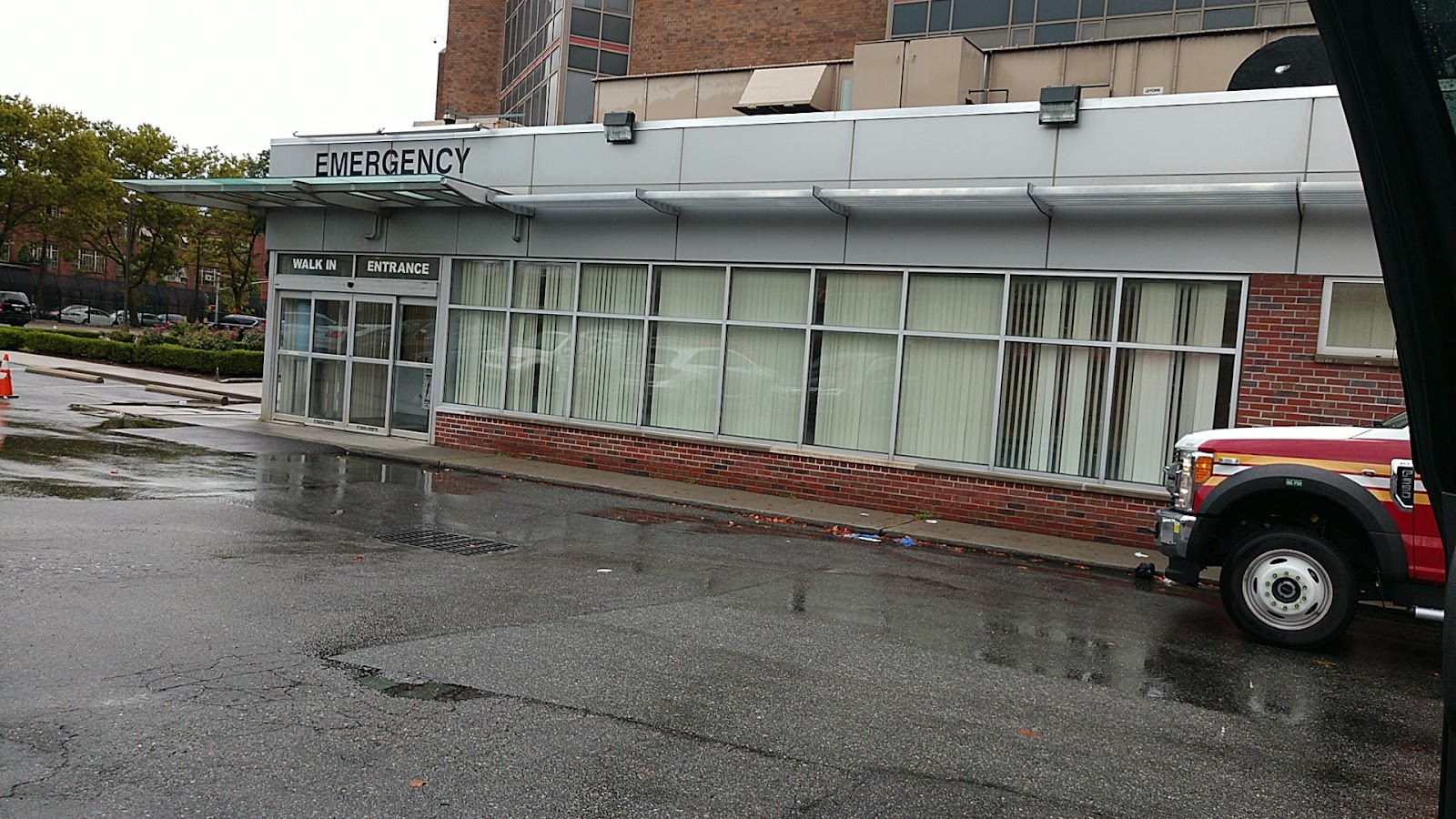 Exterior view of emergency department walk-in entrance with covered structure and brick facade