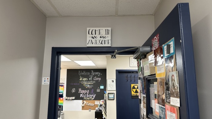 Interior hallway with Relentless Recovery branding, motivational signage about stages of change, and bulletin boards with resources