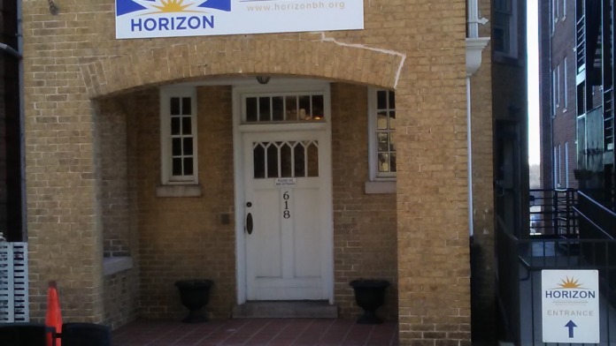Exterior view of three-story brick building with Horizon Executive Offices signage and entrance doors at street level