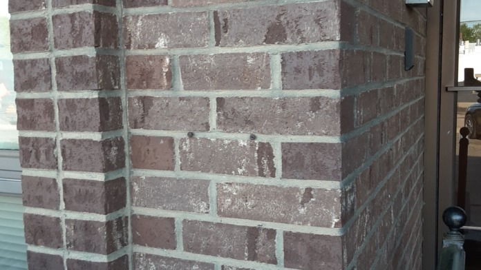 Exterior building corner with address number 554 on brick wall and glass entrance door with Spero Health signage