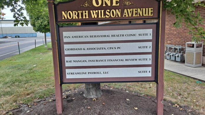 Exterior directory sign displaying One North Wilson Avenue and Pan American Behavioral Health Clinic Suite 1 location