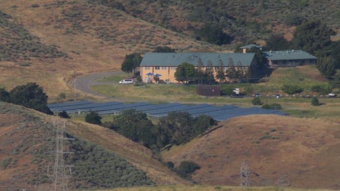 Aerial view of treatment facility main building with parking, grounds, and rolling hillside landscape