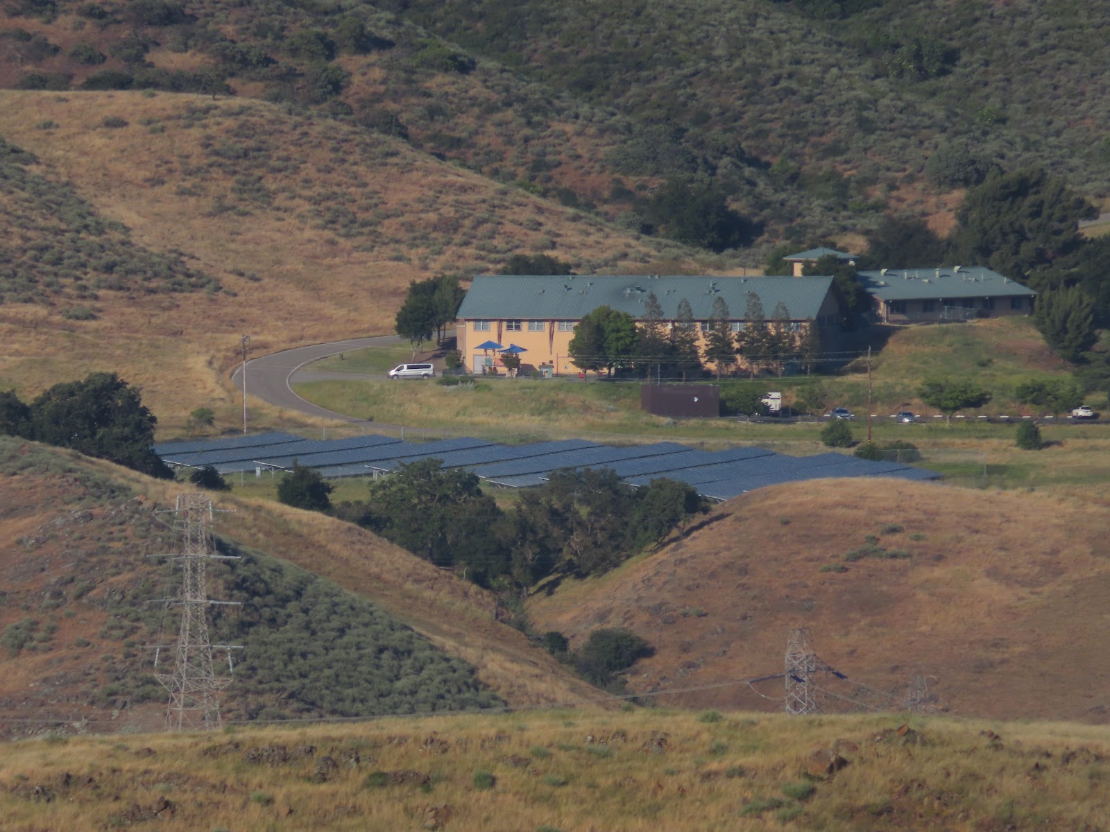 Aerial view of treatment facility main building with parking, grounds, and rolling hillside landscape