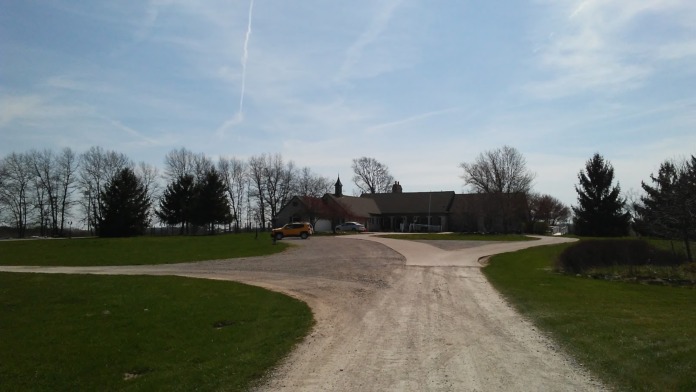 Exterior view of treatment center building accessed by gravel driveway with landscaped grounds and surrounding trees