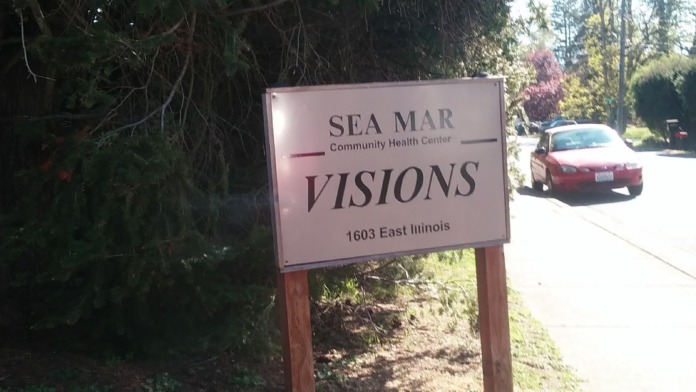 Exterior sign for Sea Mar Visions at 1603 East Illinois with landscaping and parking area visible