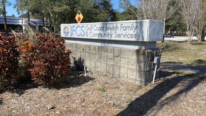 Exterior facility sign reading Gulf Coast Jewish Family and Community Services with landscaping and trees