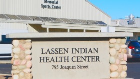 Exterior view of Lassen Indian Health Center signage with stone pillar decorations and facility address clearly displayed