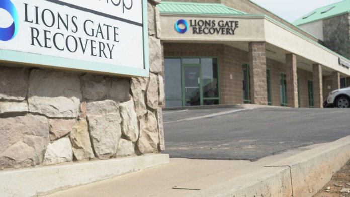 Close-up detail of stone facade and Lions Gate Recovery entrance signage on building exterior