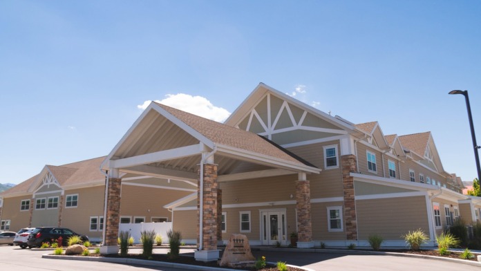 Exterior view of brick treatment center building with covered entrance portico, columns, and landscaped grounds