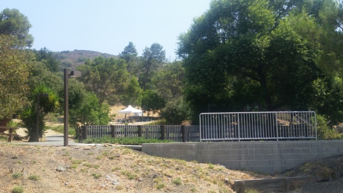 Exterior view of main building entrance with parking lot, fencing, and surrounding grounds